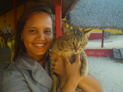 Renata Góes e gatinho tigrado na barraca de praia